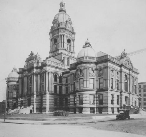 Historic building with elaborate architecture and a vintage car parked outside.