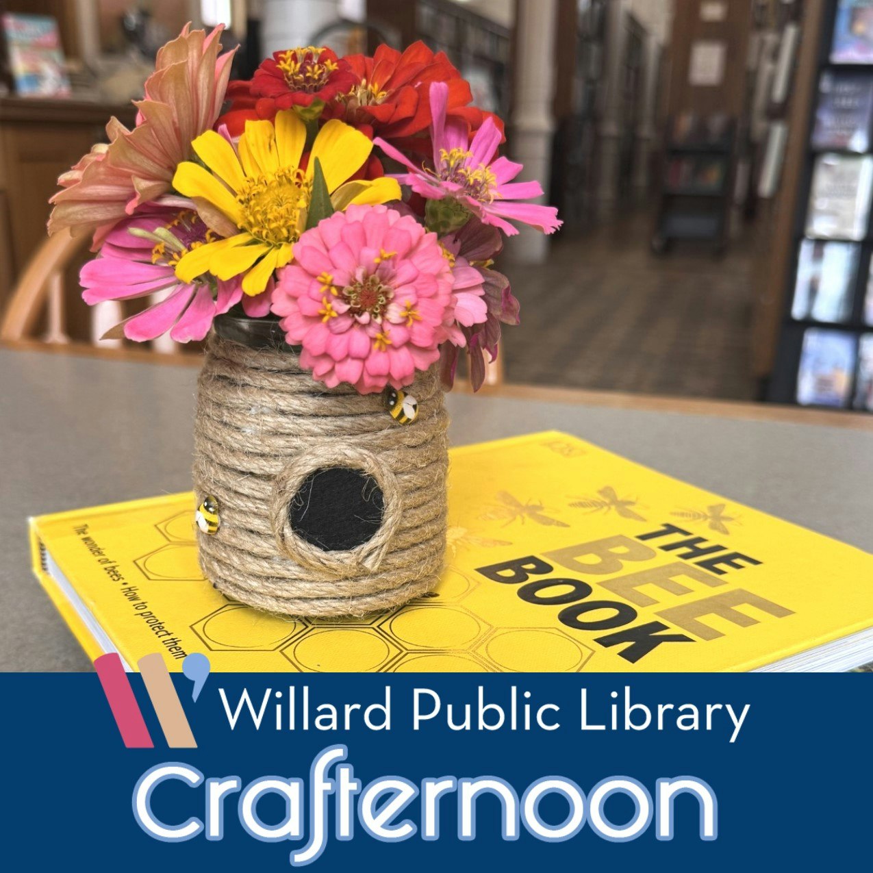 A decorative flower vase made from a jar and rope sits on a table with "The Bee Book" at Willard Public Library's Crafternoon event.