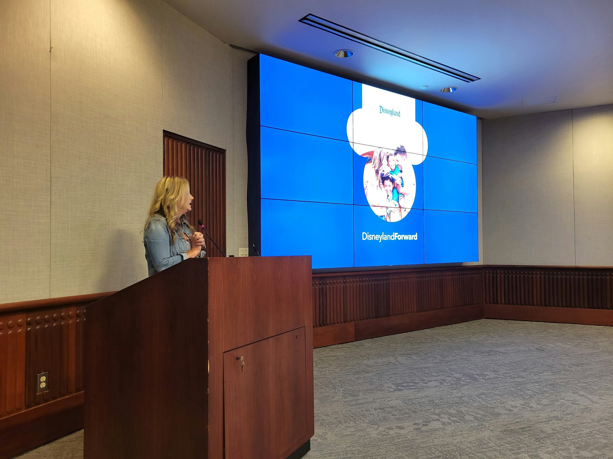 A person presenting with a slide titled "Disneyland Forward."