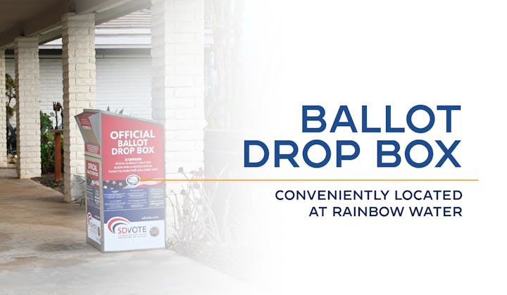 Official ballot drop box outside a building, text indicates location at Rainbow Water.
