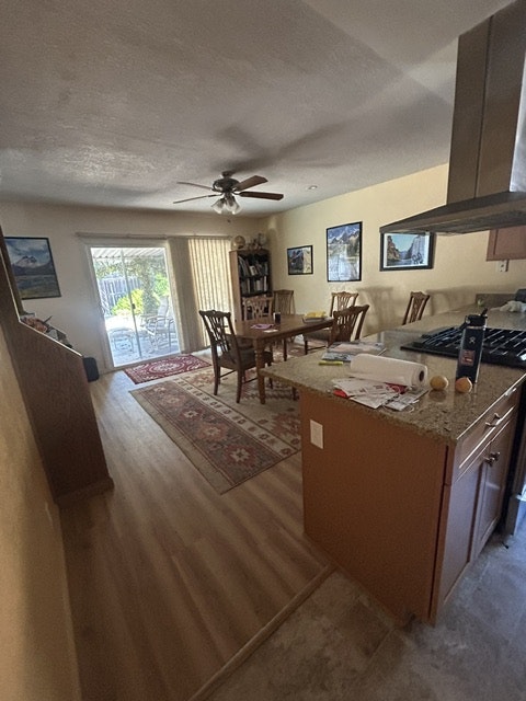 The image shows a kitchen area with a dining table, chairs, a window, and some artwork on the walls.