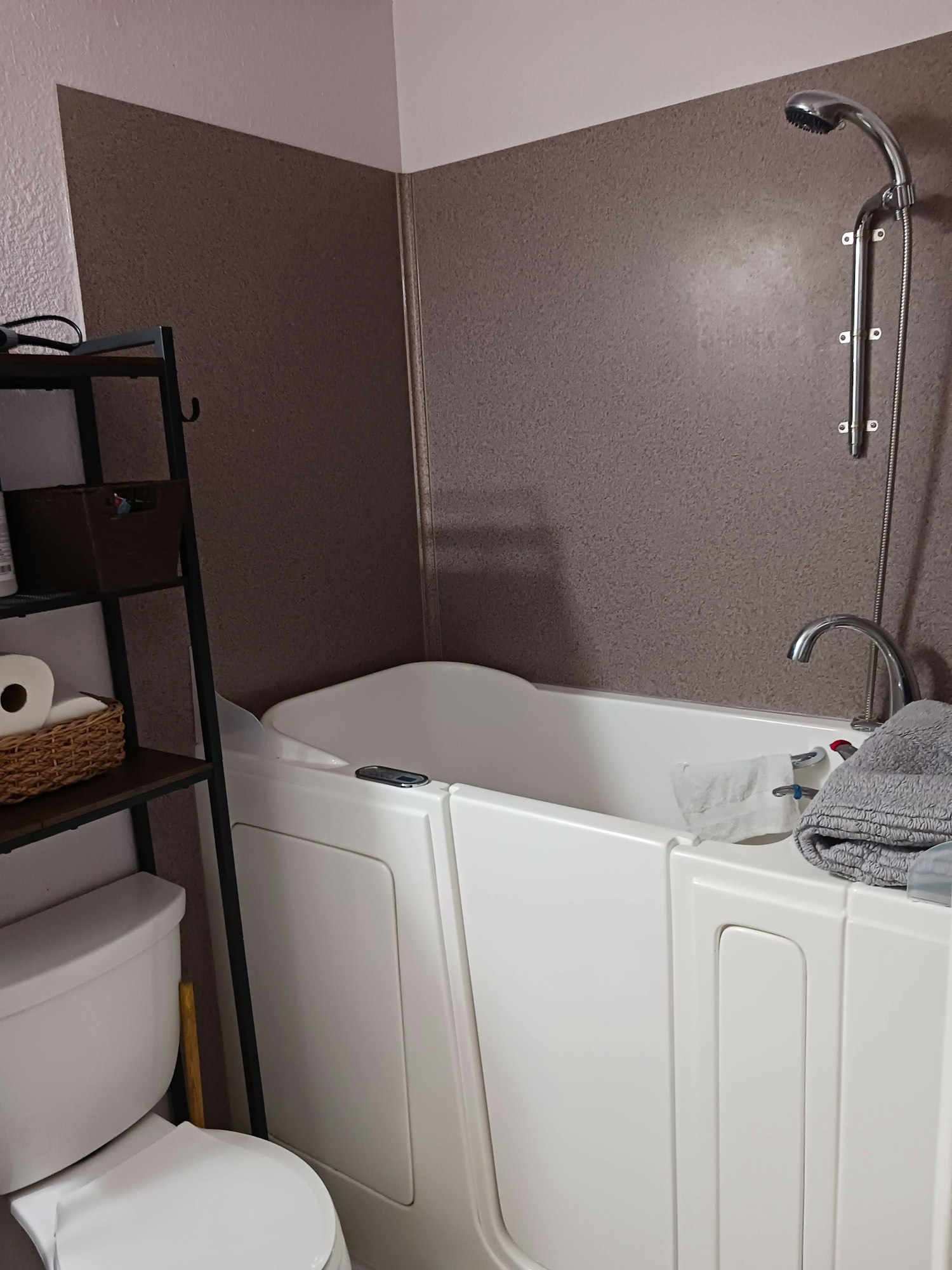 The image depicts a cozy bathroom with a shower, towel, and toilet, showcasing neat fixtures and decor.