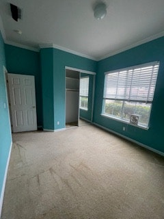 A room with teal walls, a carpeted floor, large windows, and a closet. The space appears clean and well-lit.