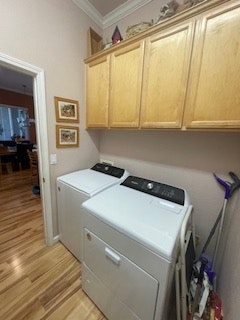 The image shows a laundry area with a washer and dryer, wooden cabinets above, and wooden flooring.