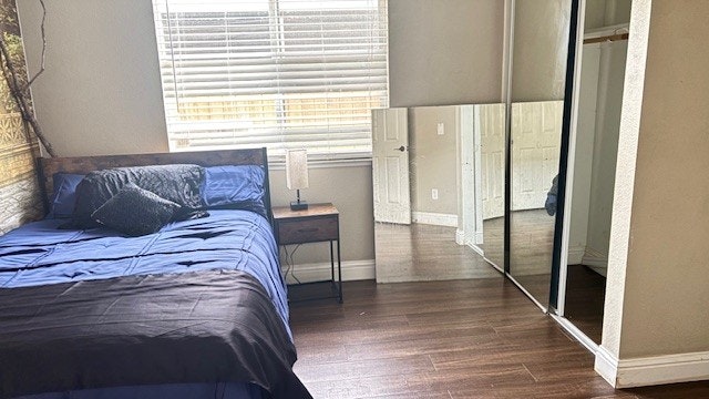A cozy bedroom with a blue bedspread, bedside lamp, and a large mirror reflecting the room's interior.