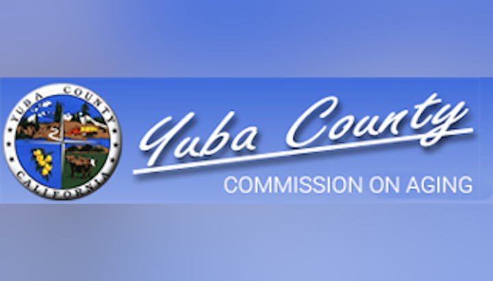 A logo of Yuba County Commission on Aging with a blue design incorporating a seal and text.