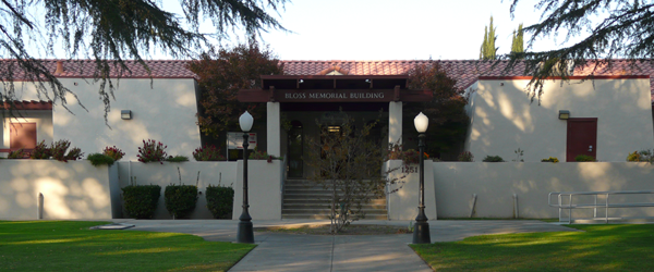 A building labeled "Bloss Memorial Building" with a front lawn, pathway, and lamp posts.