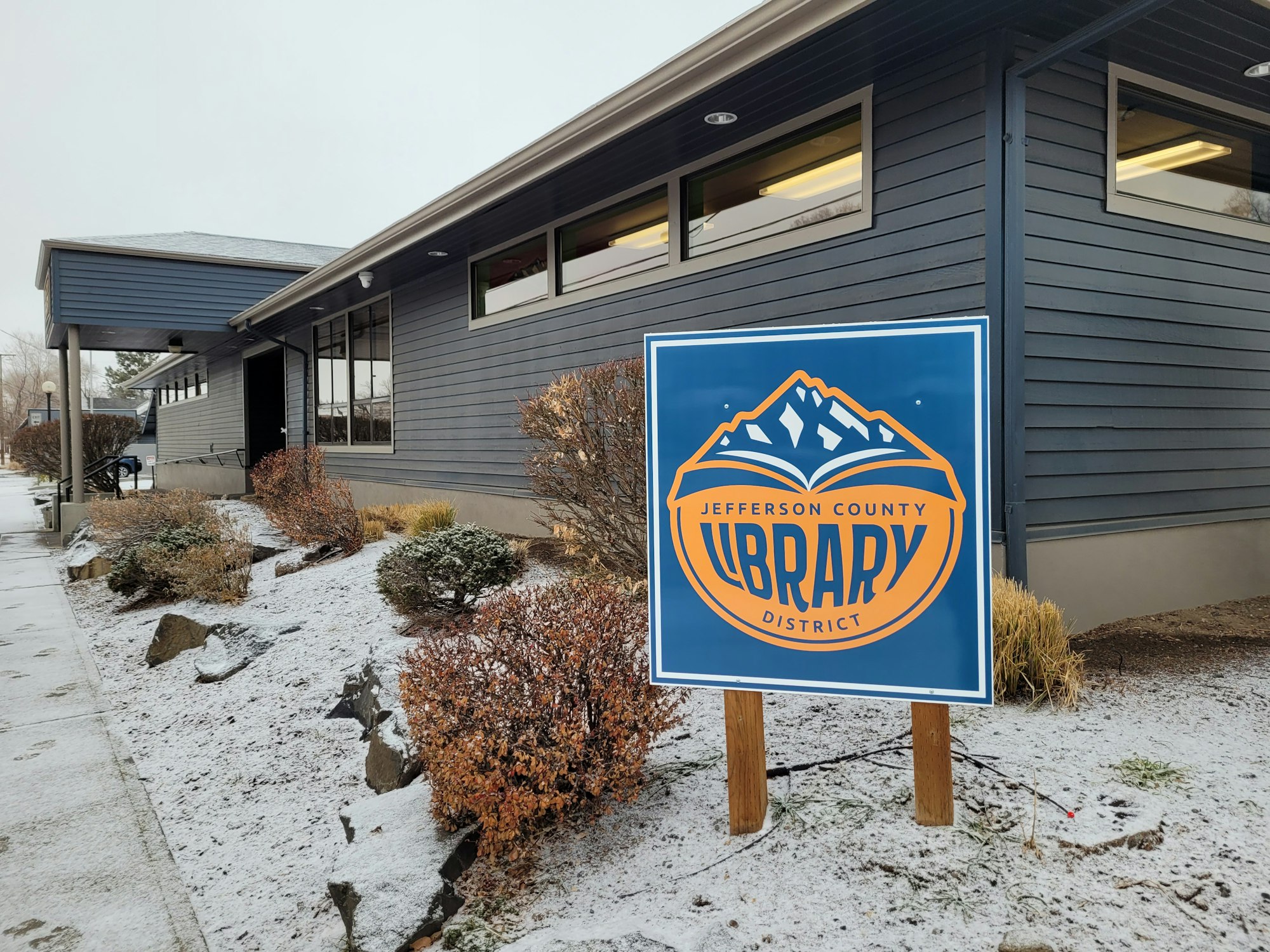 Picture of the library logo, library building in the winter