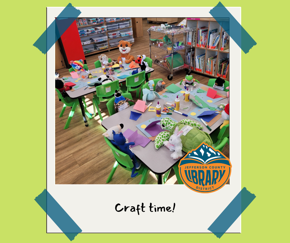 Stuffed animals around a table with art supplies.