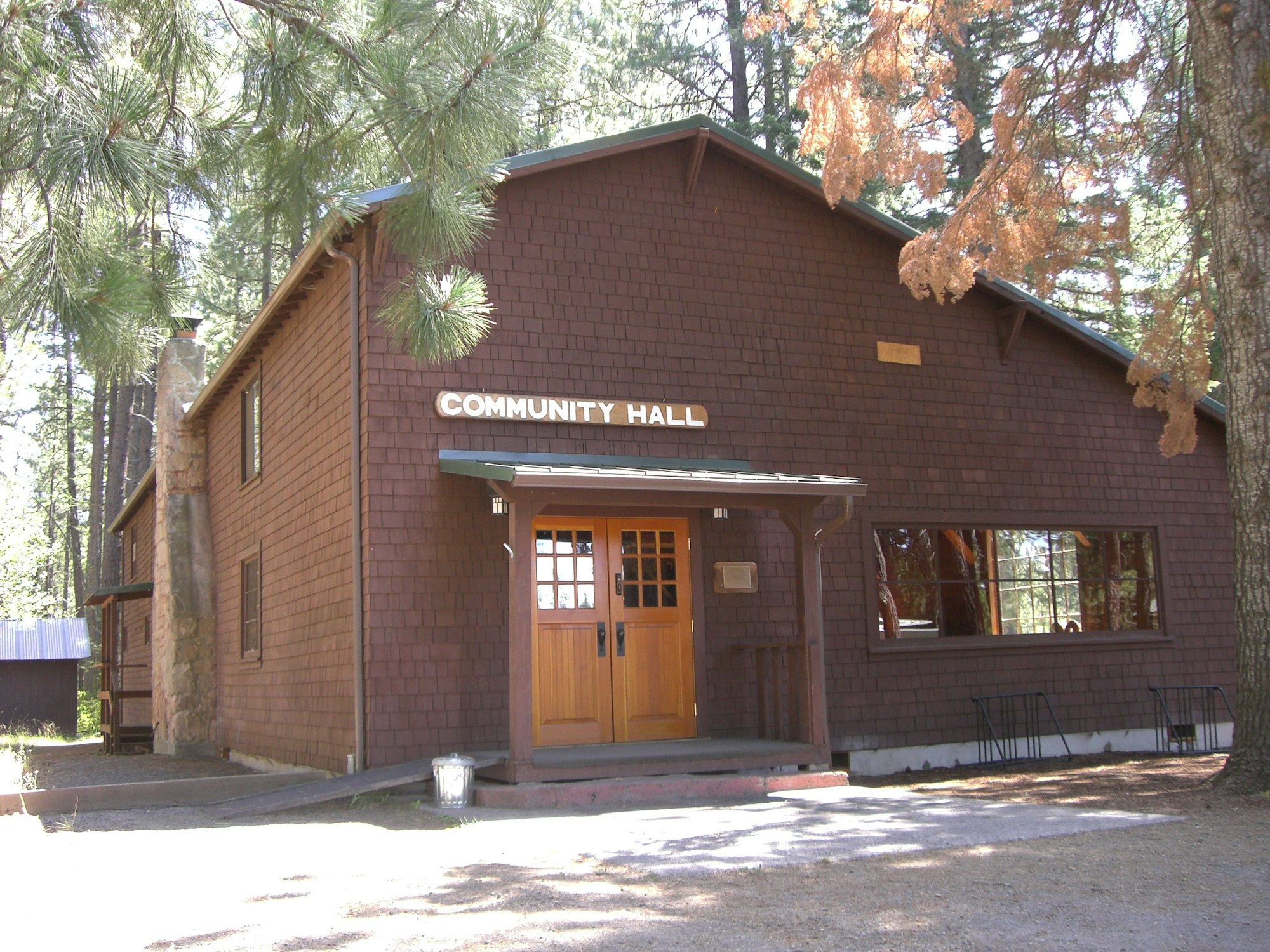 Camp Sherman Community Hall in Camp Sherman, Oregon: a wooden hall surrounded by trees, featuring a front porch and large windows.