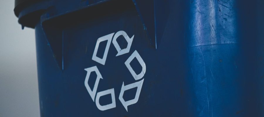A blue recycling bin with a white recycling symbol on it.