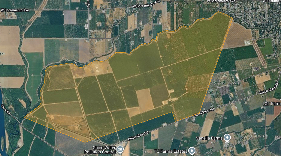Aerial view of farmland marked by an orange boundary near roads and water treatment facility with nearby farms labeled.