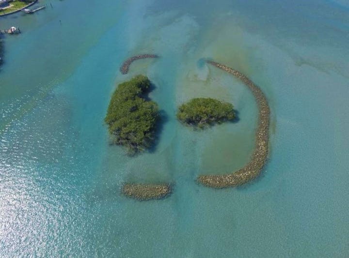 small islands with breakwaters in blue water