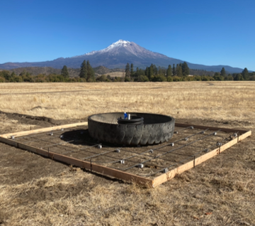 An old tire on a wooden frame, with a majestic snow-capped mountain in the background.