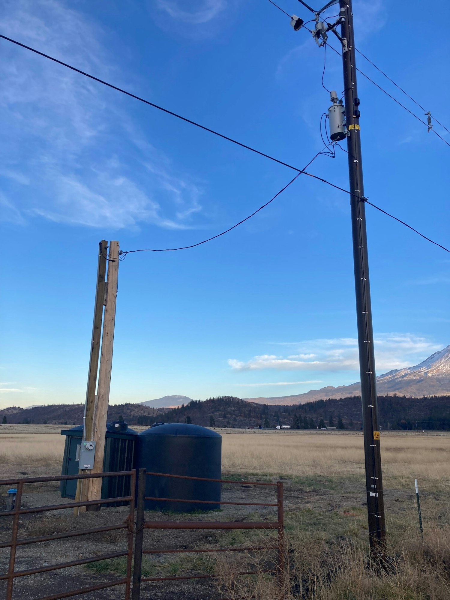 Fishing rod setup against a blue sky with a transformer and utility pole in the background.