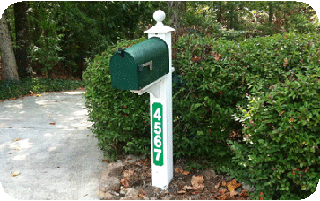 mailbox on white post with green reflective house numbers