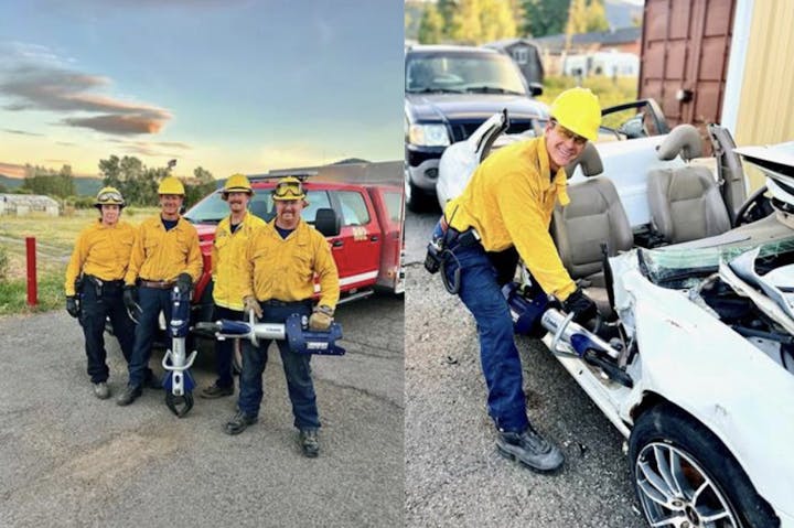 Four firefighters in yellow jackets holding equipment; one is using a hydraulic tool on a vehicle.