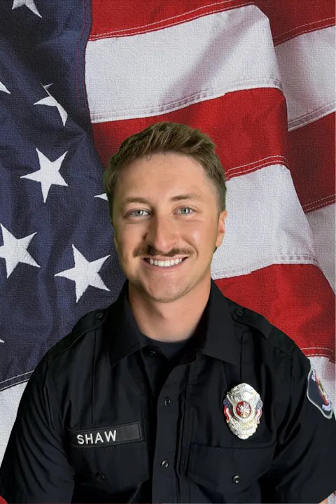 The image features a uniformed individual smiling in front of an American flag backdrop.