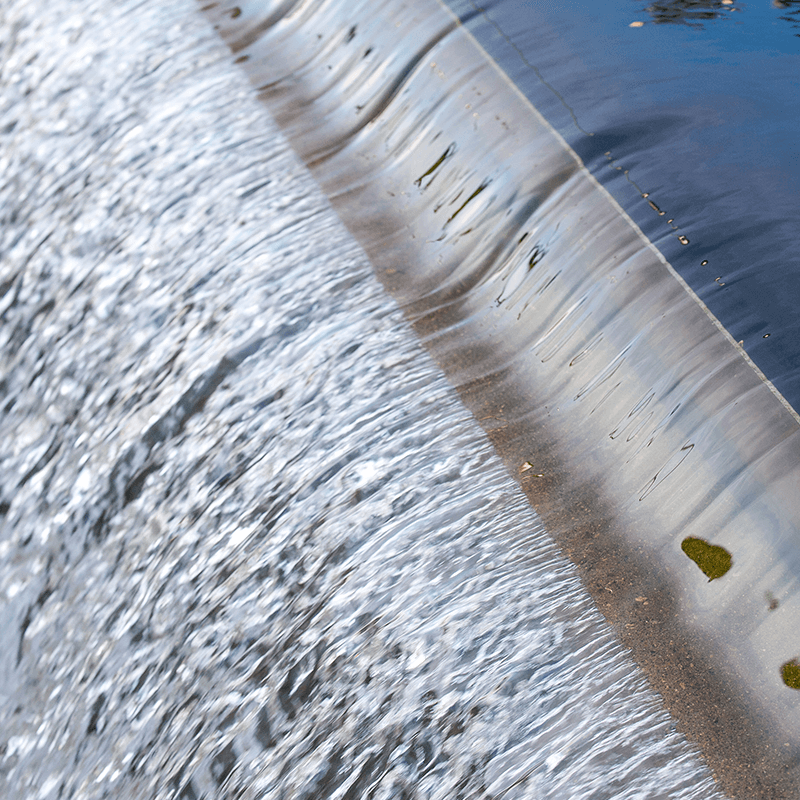 Flowing water cascading over a smooth, curved surface.