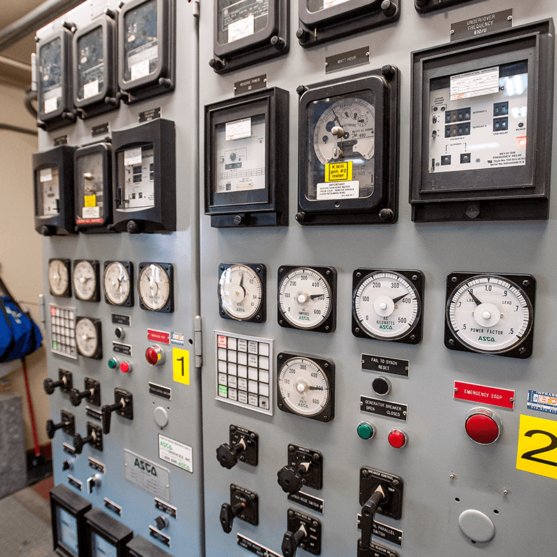 Control panel with gauges, switches, and dials, likely in an industrial or electrical setting.