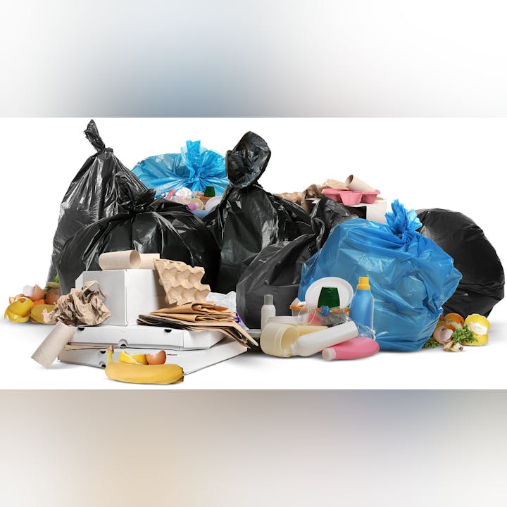 A pile of garbage bags, food waste, discarded paper, and plastic containers.