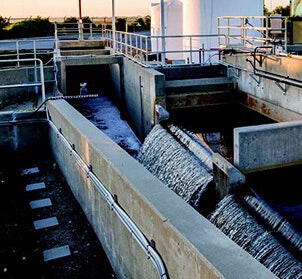 A water treatment facility with concrete channels and flowing water.