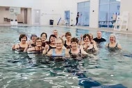 people posing for photo in pool