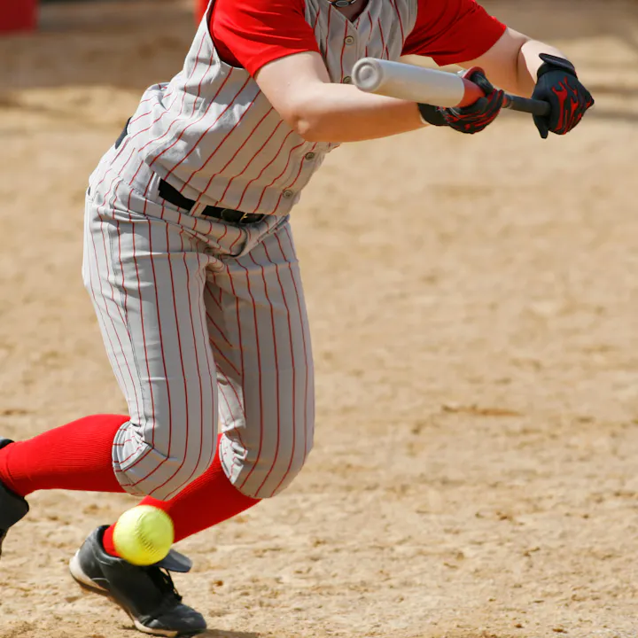 Baseball player mid-swing with ball bouncing off bat.