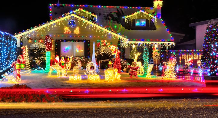 A house elaborately decorated with colorful Christmas lights and festive holiday figures.