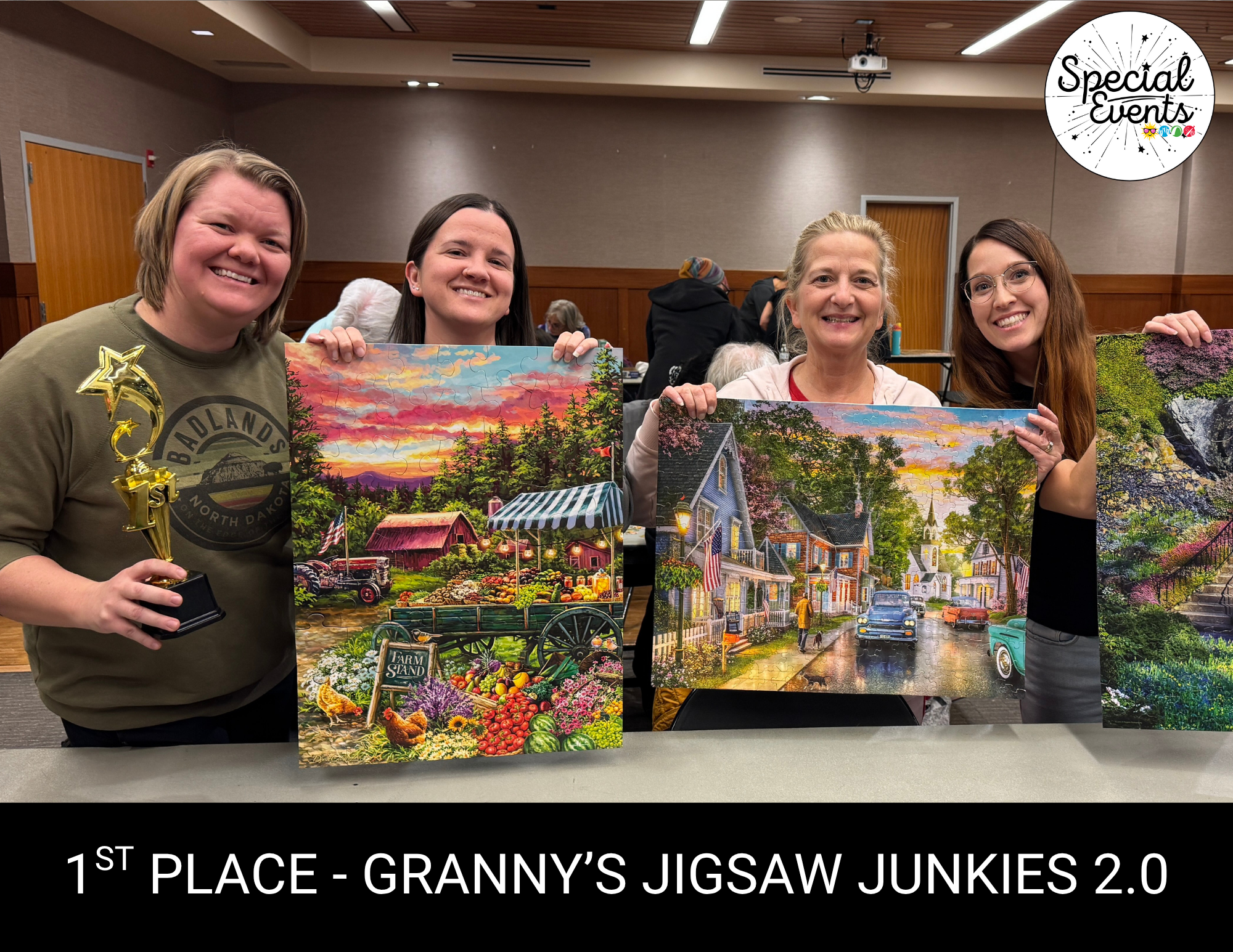 Four women proudly display jigsaw puzzle artworks and a trophy, celebrating 1st place in a competition at a special event.