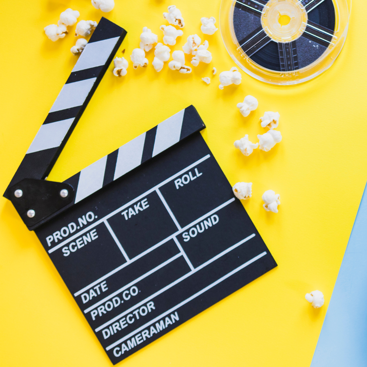 Film clapperboard, scattered popcorn, and reel on a bright yellow background.