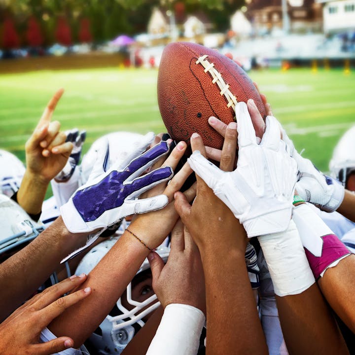 May contain: people, person, body part, finger, hand, helmet, american football, football, playing american football, sport, american football (ball), and ball