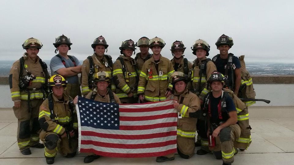 May contain: person, human, flag, symbol, helmet, clothing, apparel, and fireman