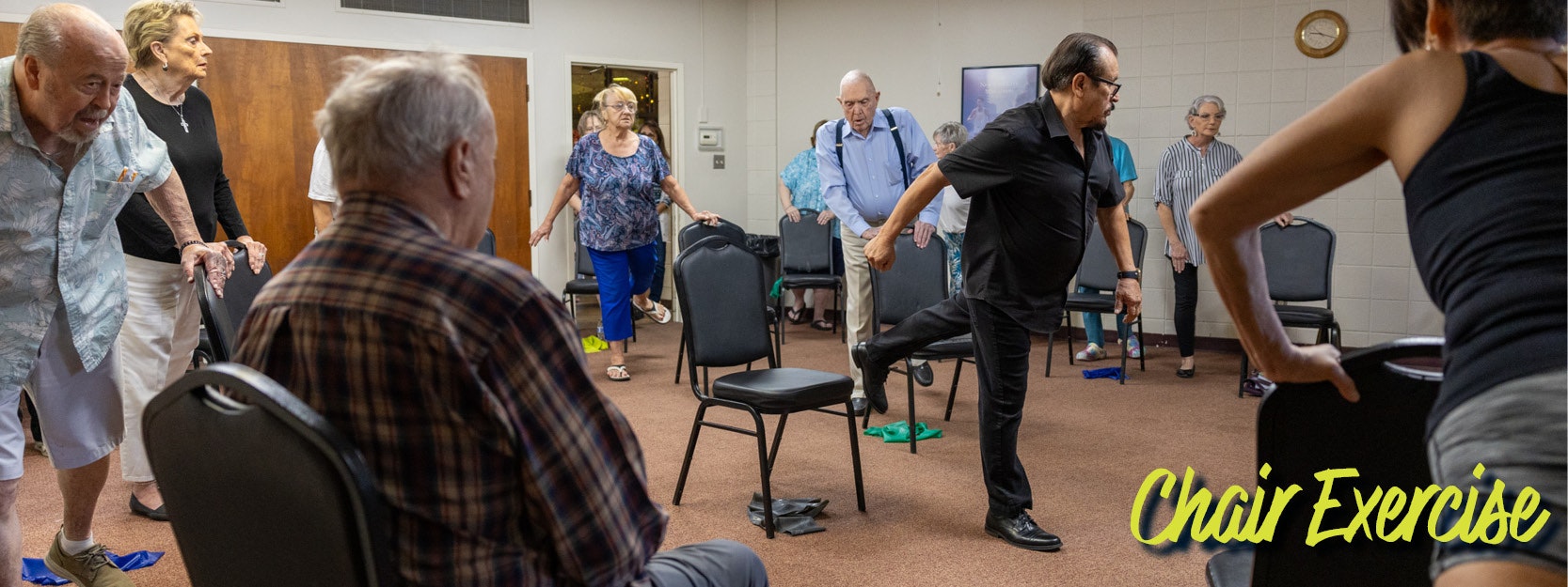 People in a group doing chair exercises in a room, with "Chair Exercise" text in the bottom right corner.