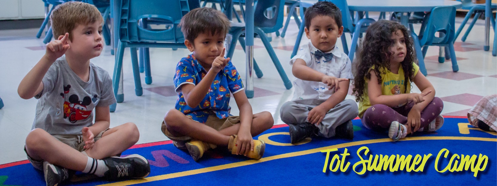 Small children sitting on a rug counting with their fingers, Tot Summer Camp