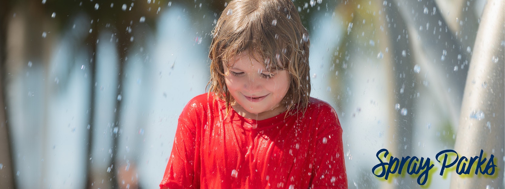 A child in a red shirt playing under water sprinkles, with "Spray Parks" text.