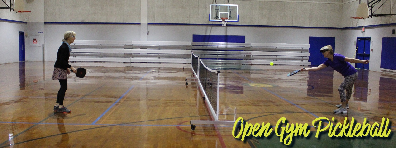 Two people playing pickleball in a gymnasium labeled "Open Gym Pickleball."