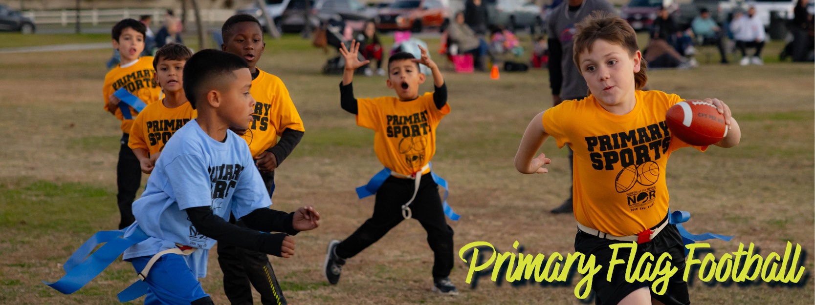 Kids playing flag football, wearing "Primary Sports" jerseys, running on a grassy field.