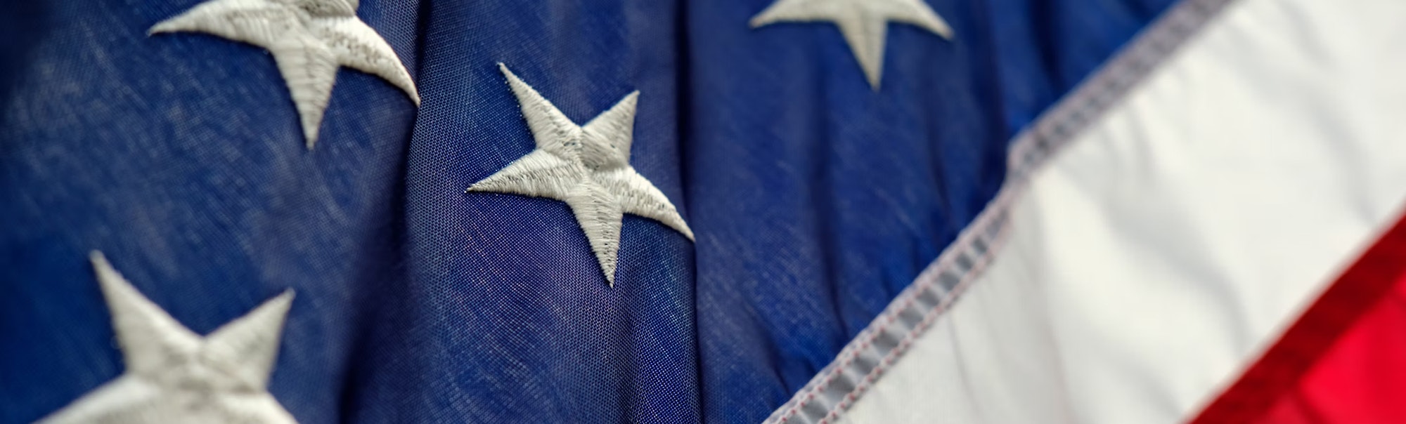Close-up of the American flag, featuring white stars on a blue field, and red and white stripes.