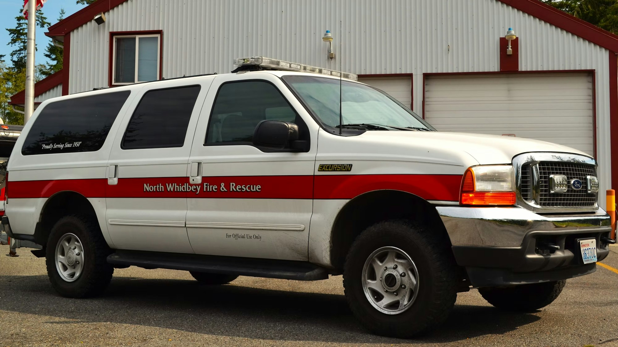 A white North Whidbey Fire & Rescue SUV parked in front of a building with red and white detailing.