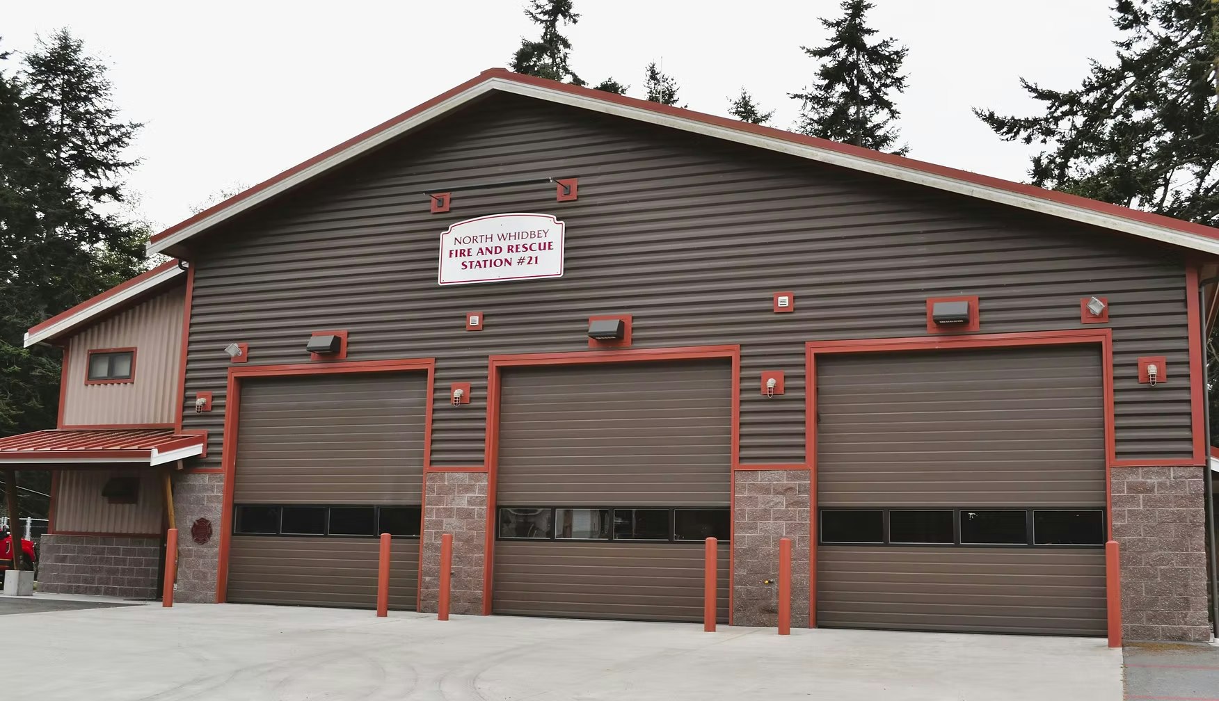 A fire station with three garage doors and signage for North Whidbey Fire and Rescue Station #21.