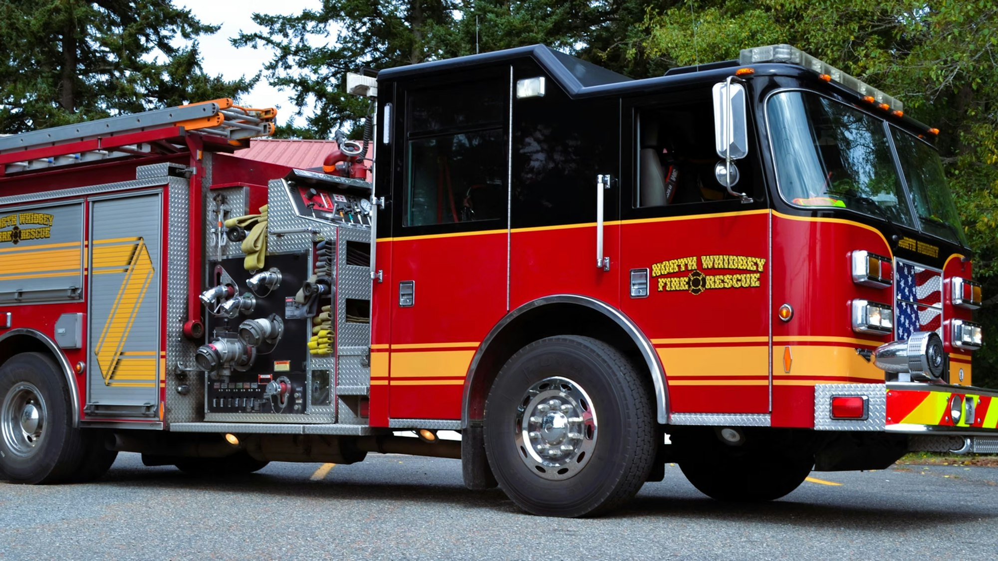 A red fire truck from North Whidbey Fire & Rescue with equipment and an American flag design visible.