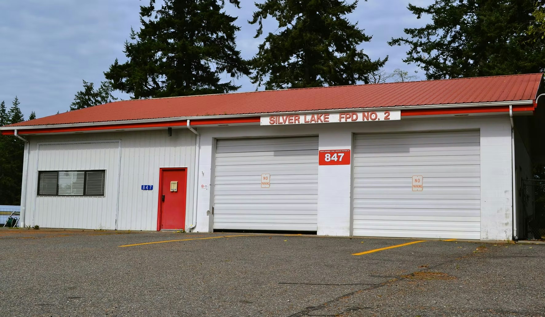 A small fire station with two garage doors, a red door, and signage saying "Silver Lake FPD No. 2" and "847."