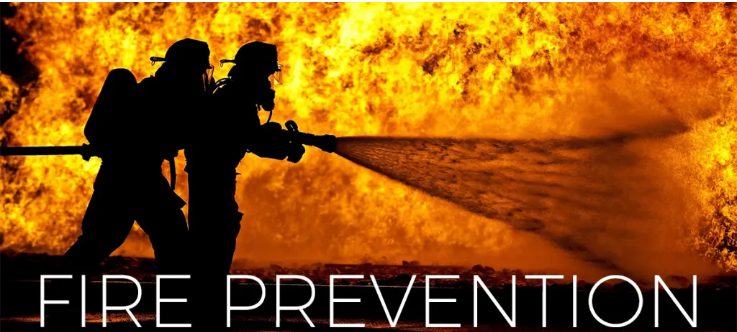 Two firefighters spray water at a large blaze, with "FIRE PREVENTION" text below.