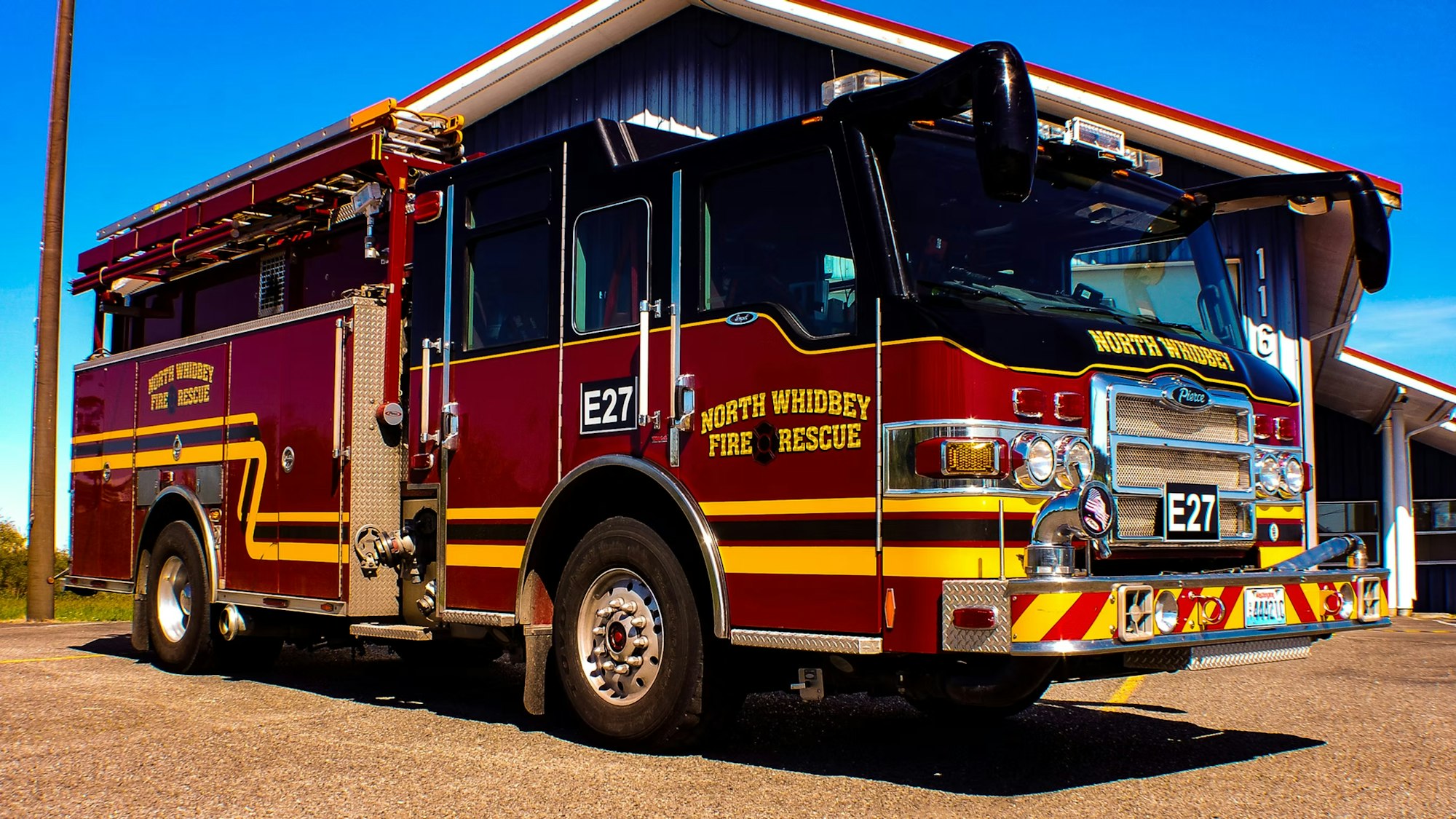 A red and yellow fire truck labeled "North Whidbey Fire Rescue" parked in front of a building.