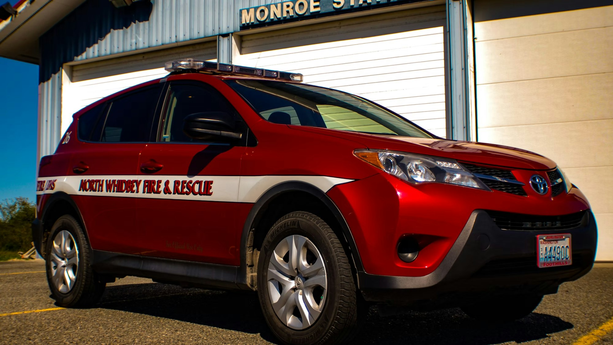 Red Toyota vehicle marked "North Whidbey Fire & Rescue" parked at Monroe Station.