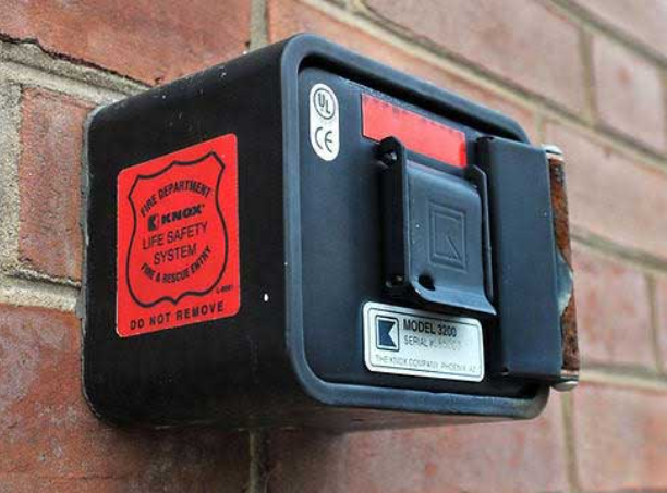 A fire department life safety system box mounted on a brick wall, labeled as "Knox Model 3200."