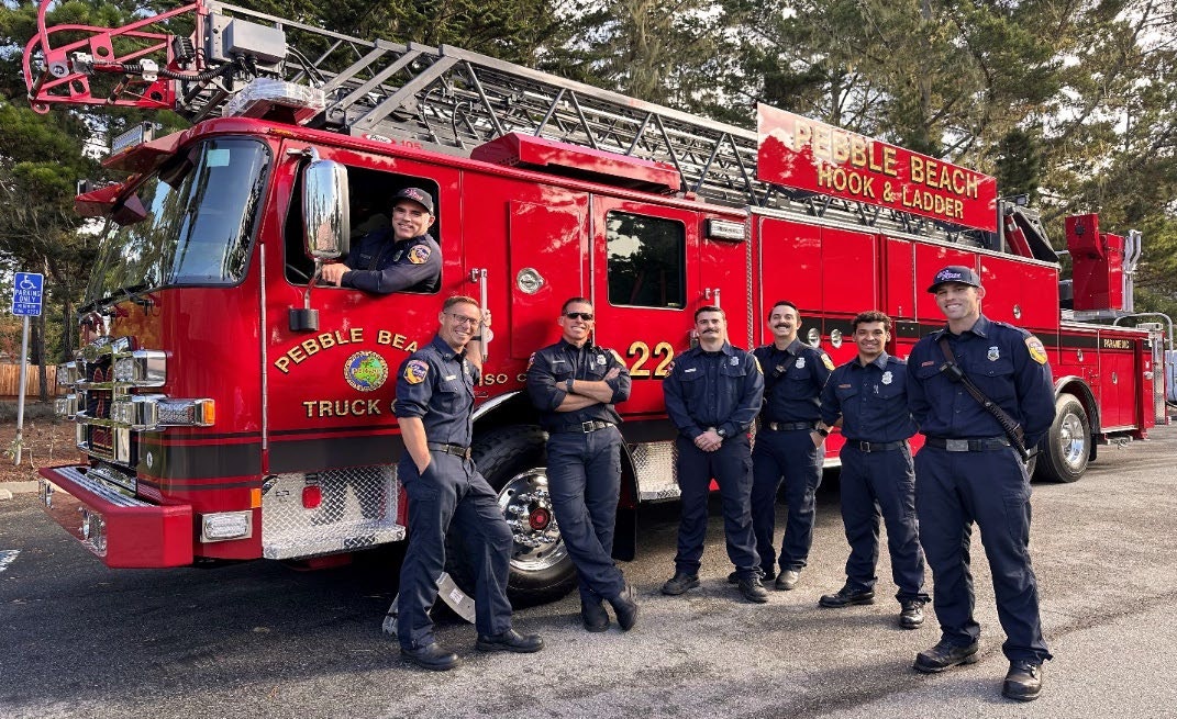 Firefighters posing in front of a red fire truck labeled "Pebble Beach Hook & Ladder."