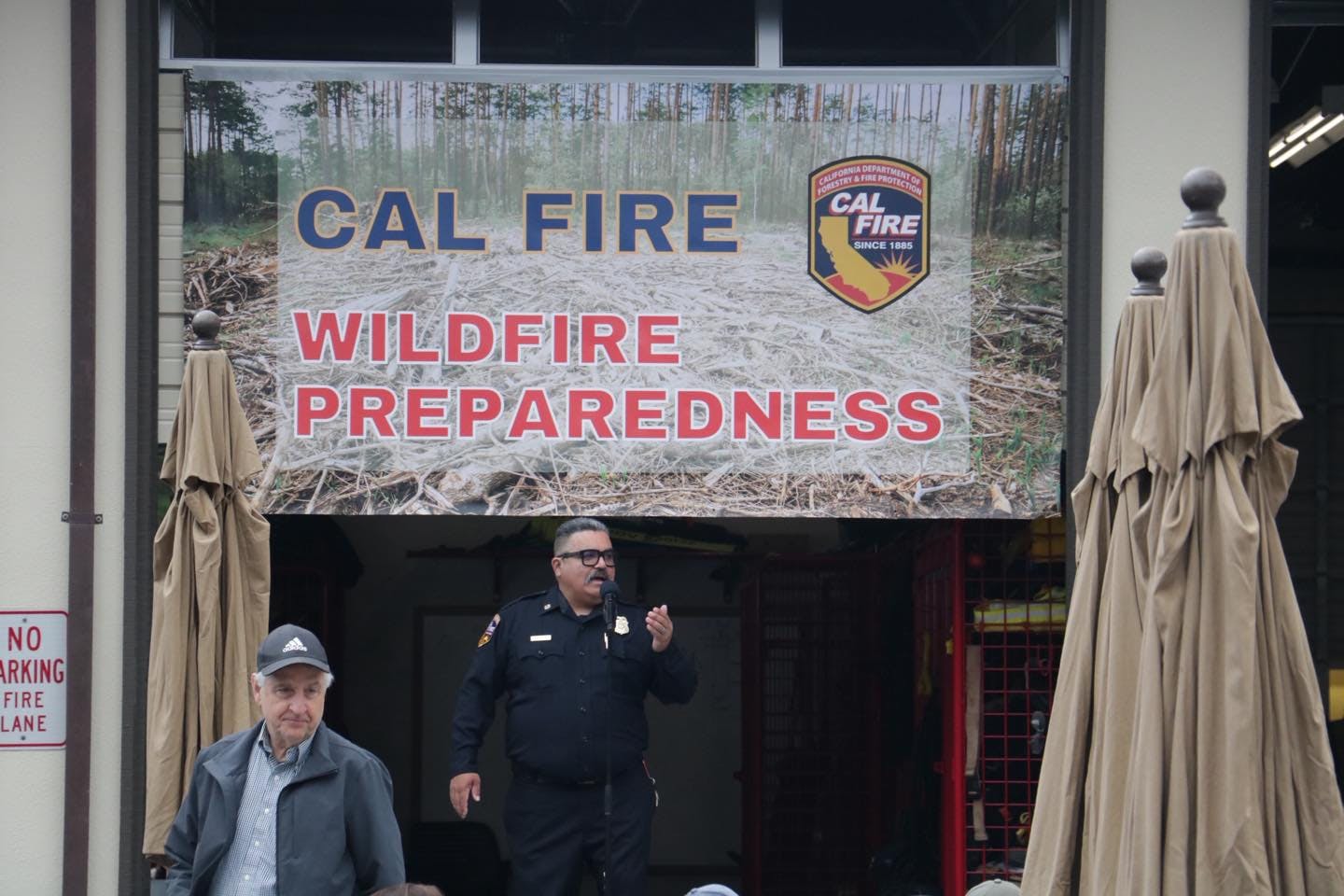 A CAL FIRE wildfire preparedness event with a sign and people present.