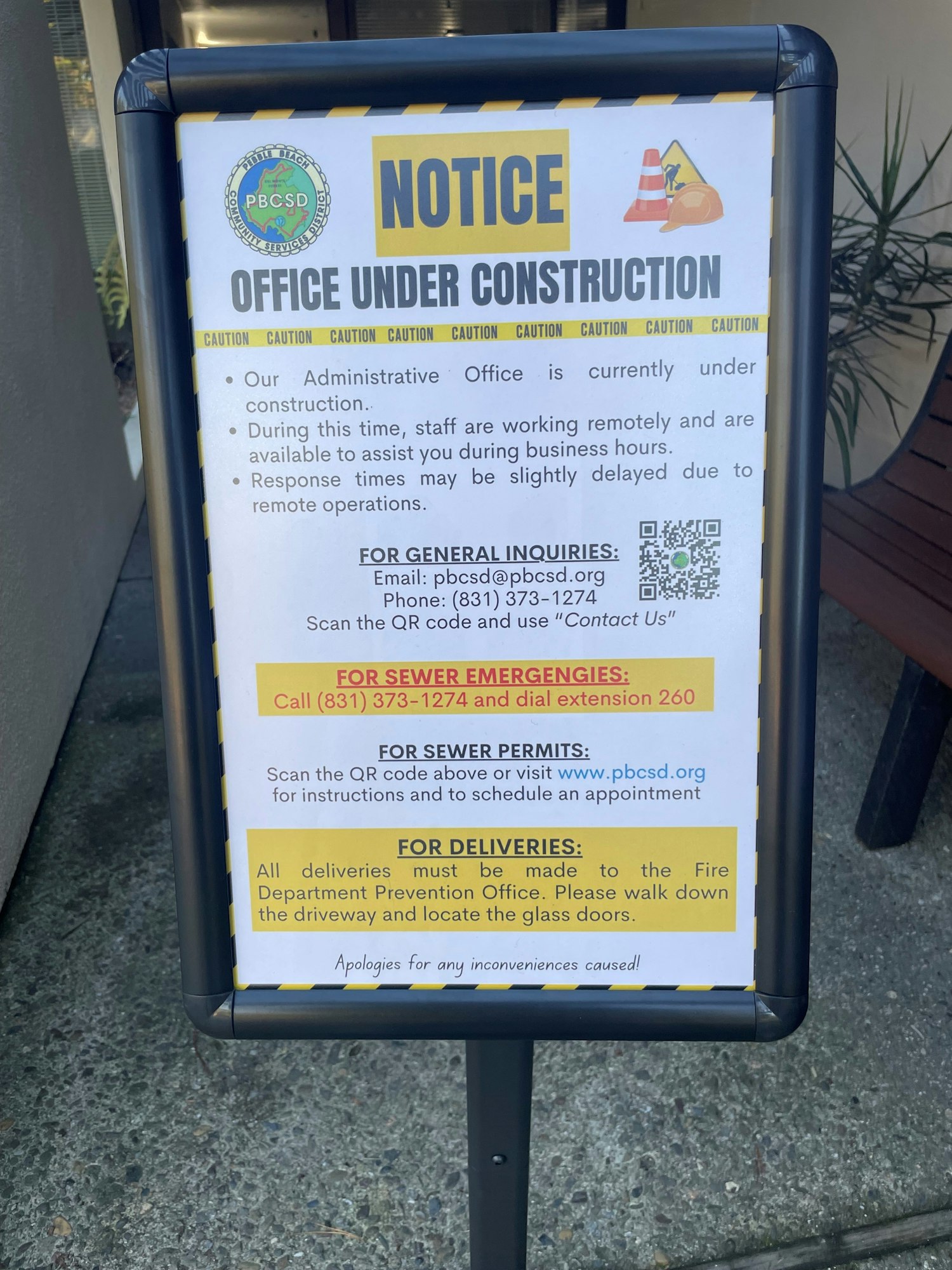 Sign indicates the administrative office is under construction, with staff working remotely. Contact info and delivery instructions provided.